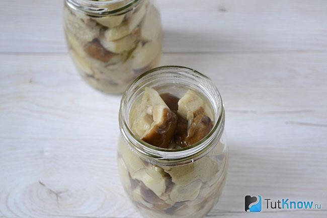 Кусочки грибов разложены по банкам