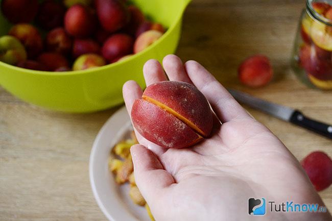 Разрезанный персик в руке