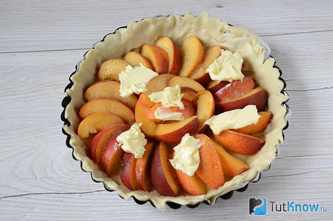 Кусочки сливочного масла на дольках персиков