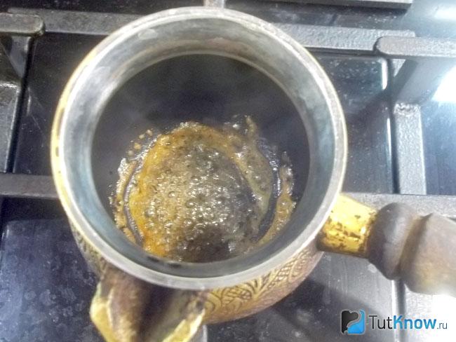 Турка с сахаром нагревается на огне до карамелизации рафинада