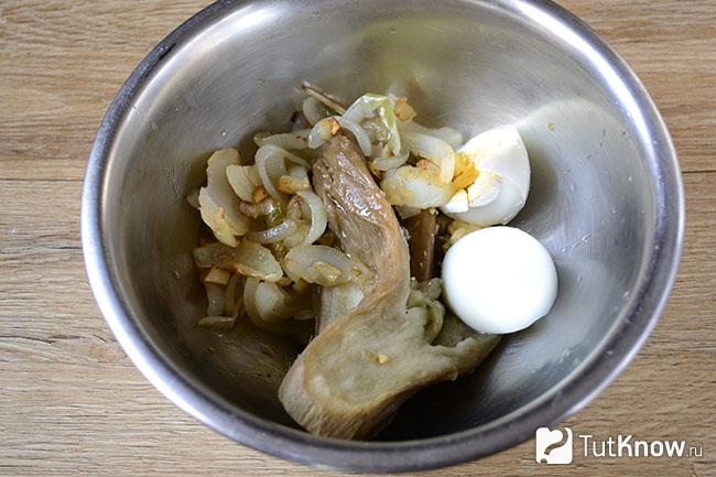 Кусочки печеного баклажана, жареный лук и яйца в одной миске