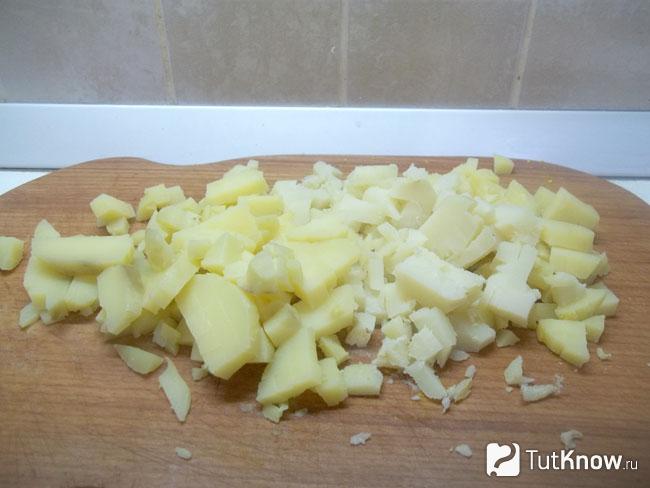 Отваренный картофель очищен и нарезан кубиками