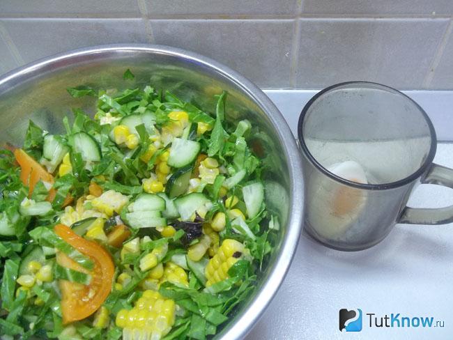 Салат с капустой, кукурузой заправлен маслом и перемешан