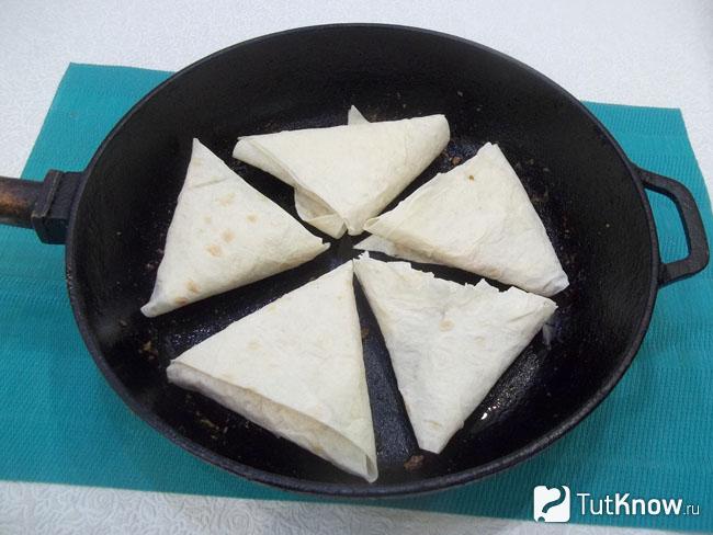 Треугольники из лаваша с курицей жарятся в сковороде