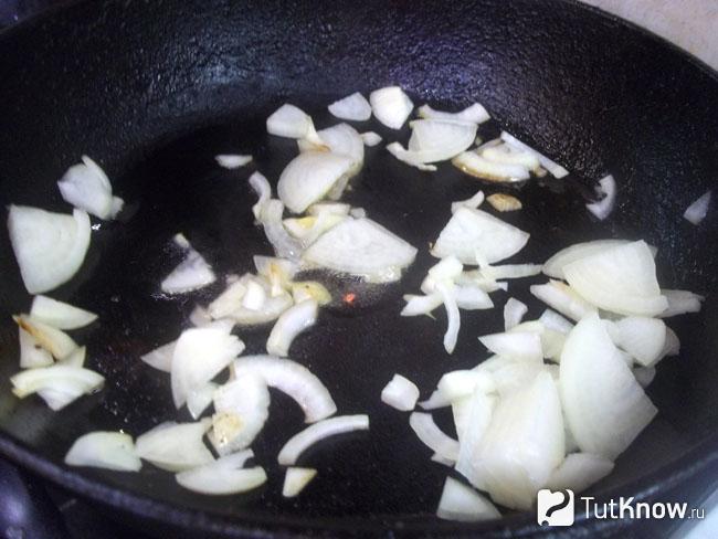 Лук нашинкован полукольцами и жарится в сковороде