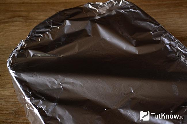 Форма с кусочками тыквы и яблок покрыта фольгой