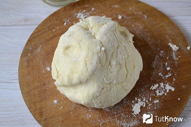 Большой кусок теста на кухонной доске