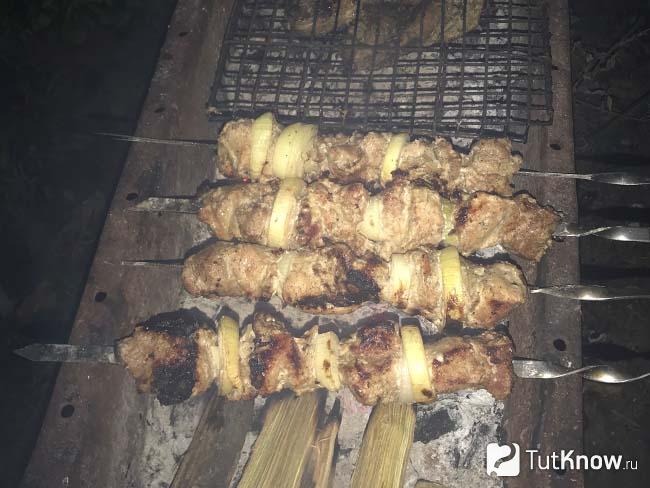 Мясо жарится на мангале