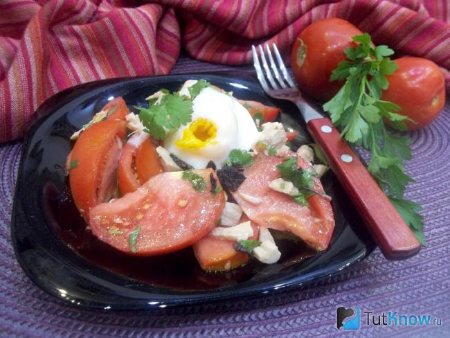 Готовый салат с курицей, помидорами, зеленью и яйцом-пашот
