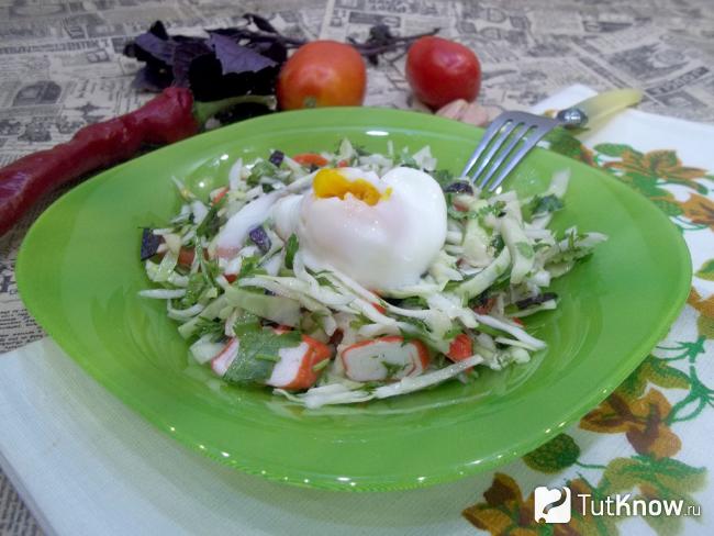 Готовый салат с крабовыми палочками, помидорами, капустой и яйцом-пашот