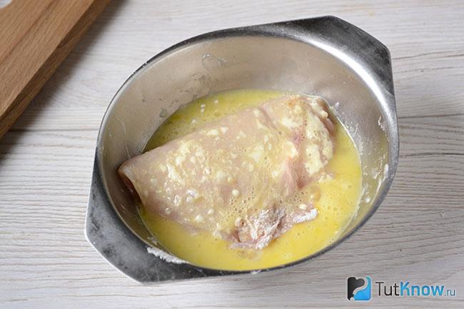 Заготовка для куриной отбивной в миске со взбитым яйцом