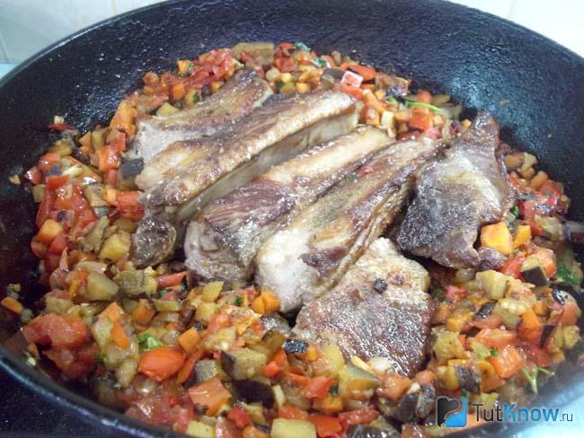 Мясо добавлено в сковороду к овощам и готовится блюдо под крышкой