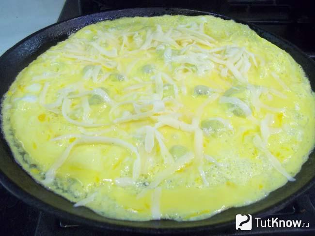 Яичная масса присыпана сырной стружкой