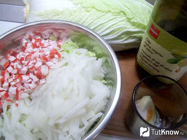 Капуста, редька и крабовые палочки сложены в тарелку