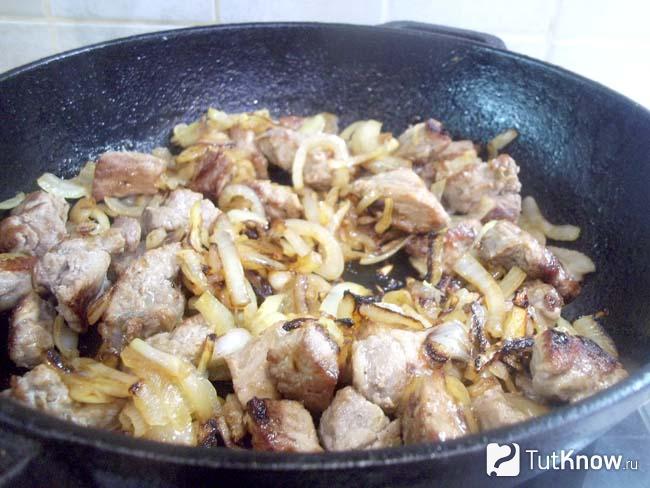 Мясо с луком жарится в сковороде