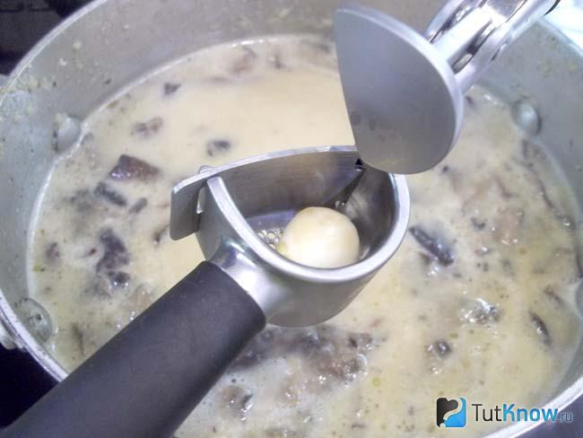 Готовый сливочно-грибной суп-пюре с кабачками и сметаной приправлен чесноком
