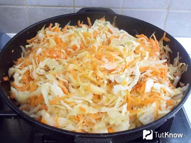 Капуста с морковью жарятся в сковороде