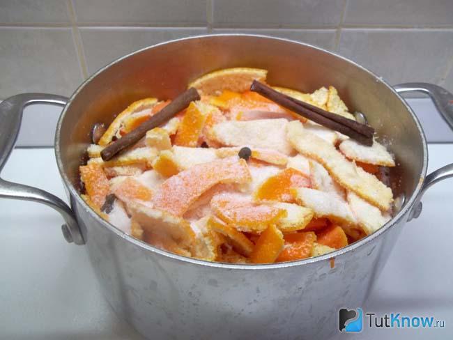 Мандариновые корки выложены в кастрюлю и засыпаны сахаром