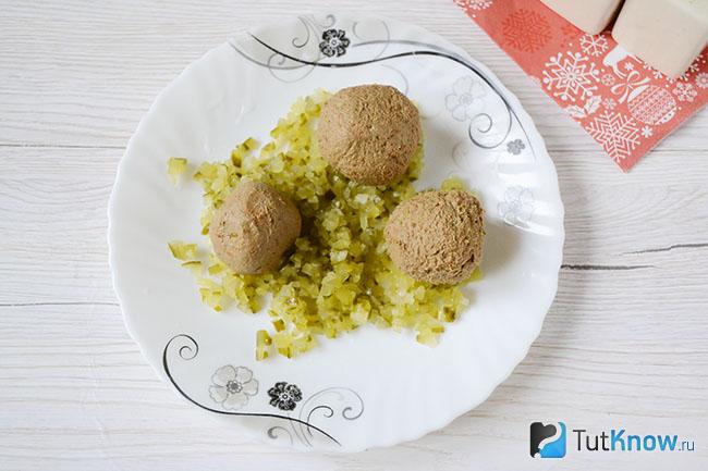 Нарубленный солёный огурец с шариками из печени