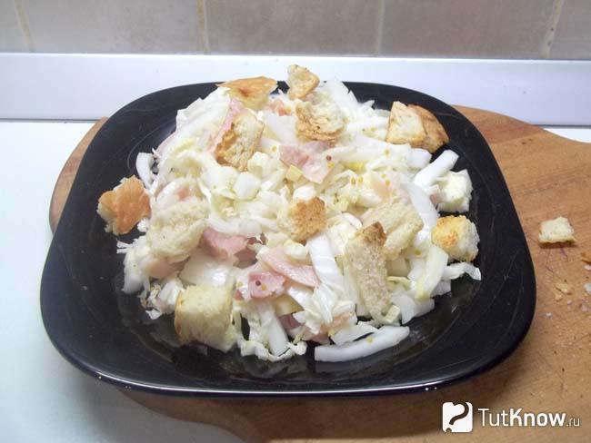 Салат с пекинской капустой и копченой курицей присыпан сухариками