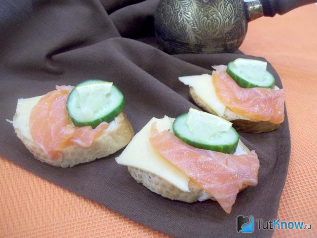 Готовые бутерброды с красной рыбой, сыром, огурцом и лимоном