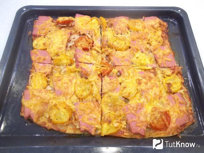 Готовая пицца маринара с колбасой, сыром и помидорами нарезана кусочками
