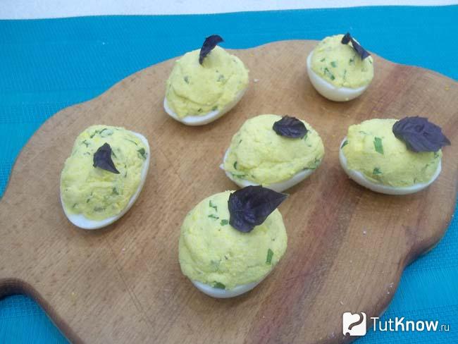 Готовые фаршированные яйца с плавленым сыром и огурцами