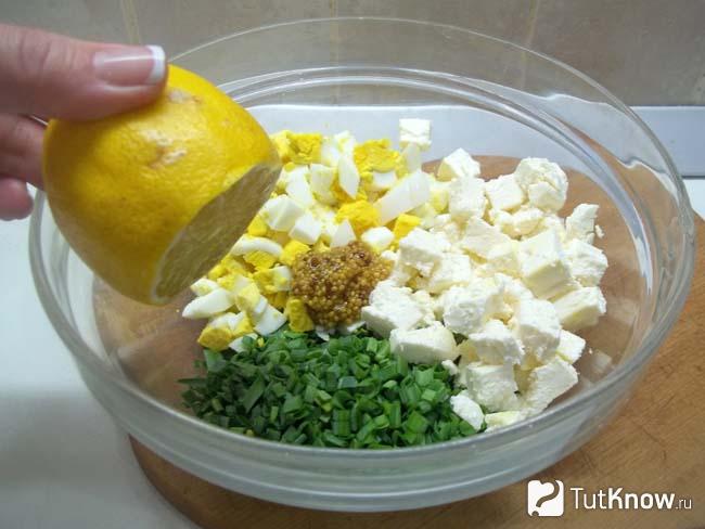 Салат с яйцами, зеленым луком и сыром заправлен лимонным соком