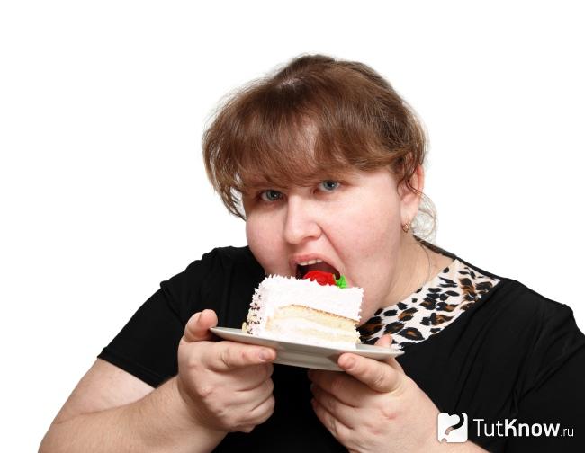 Толстая женщина ест пирожное