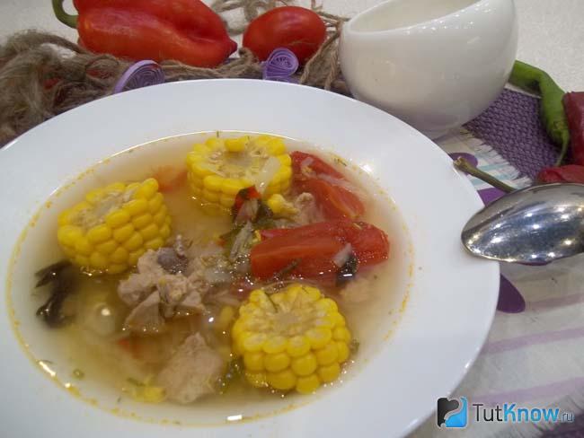 Готовый куриный суп с кукурузой, помидорами и яйцами