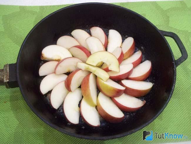 В сковороду выложены яблоки нарезанные дольками