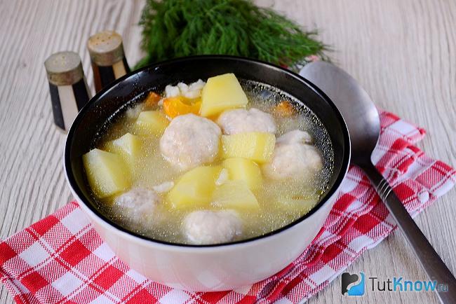 Готовый рисовый суп с мясными фрикадельками в кастрюле