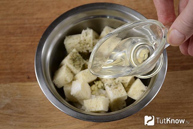 Добавление растительного масла к кубикам хлеба