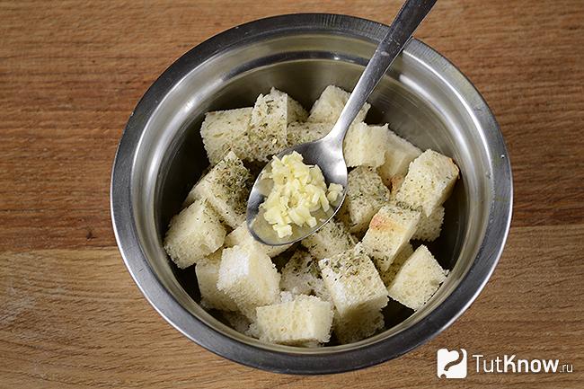 Добавление чеснока к кубикам хлеба