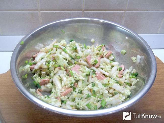 Салат с колбасой, луком и пекинской капустой заправлен маслом