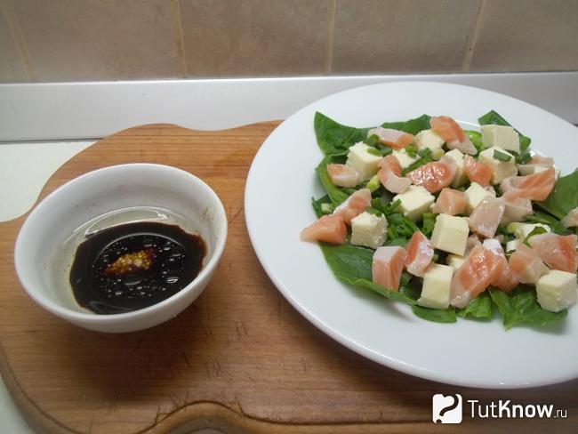 Приготовлен соус и заправлен им салат со шпинатом, красной рыбы и сыра