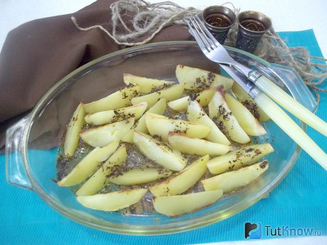 Готовый запеченный картофель по селянски в масле с пряностями в духовке