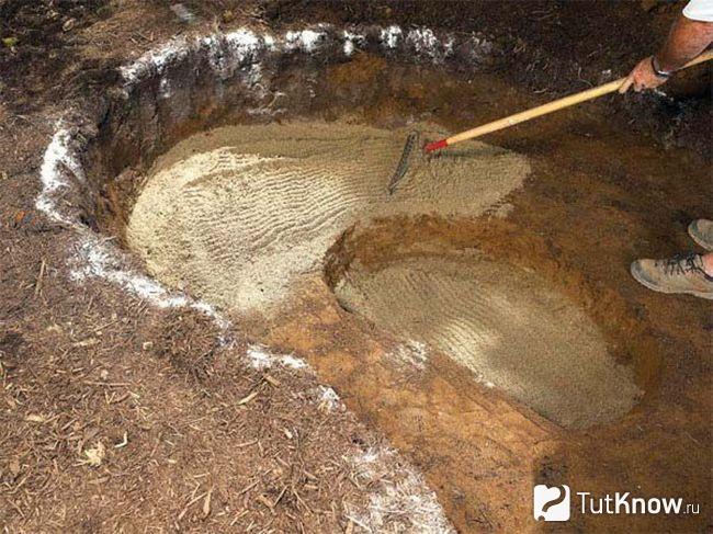 Укладывание песка в котловане под водоём
