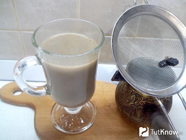 Готовое кофе в турке с корицей на молоке и воде перелит в чашку через фильтрацию
