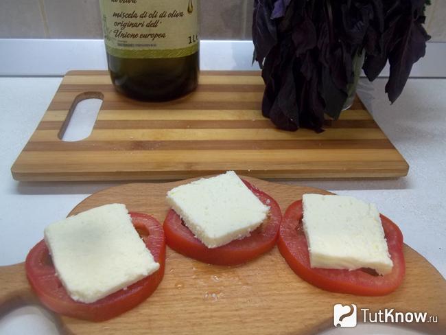 сыр нарезан ломтиками и выложен на помидоры