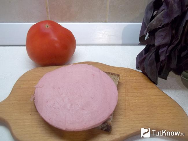 Ломтик колбасы выложен на кусок хлеба