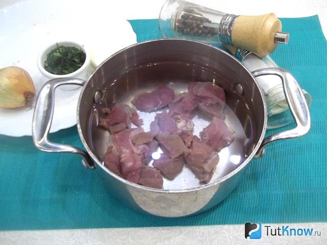 Мясо нарезано, сложено в кастрюлю и залито водой