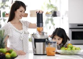 Женщина готовит сок своей дочке