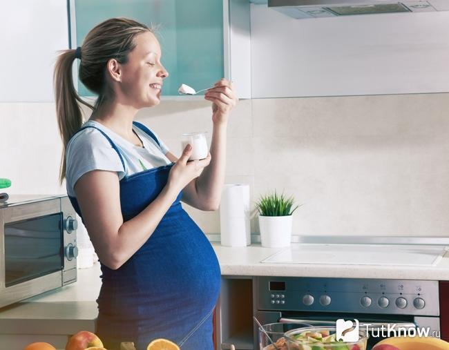 Беременная женщина кушает козий творог