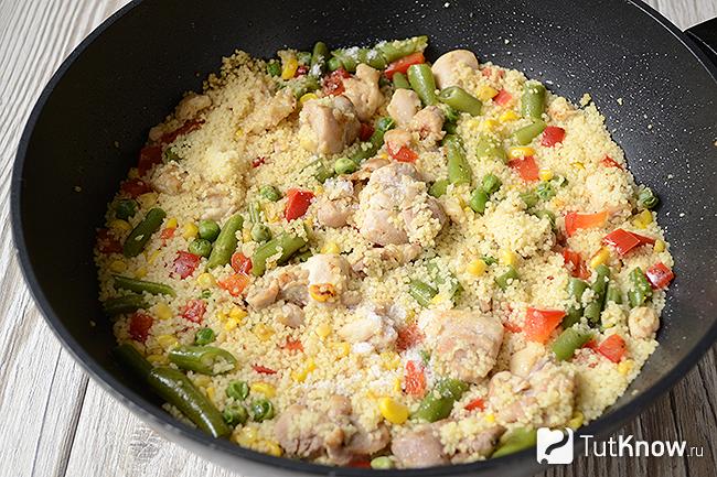 Готовый кускус с курицей и овощами на сковороде