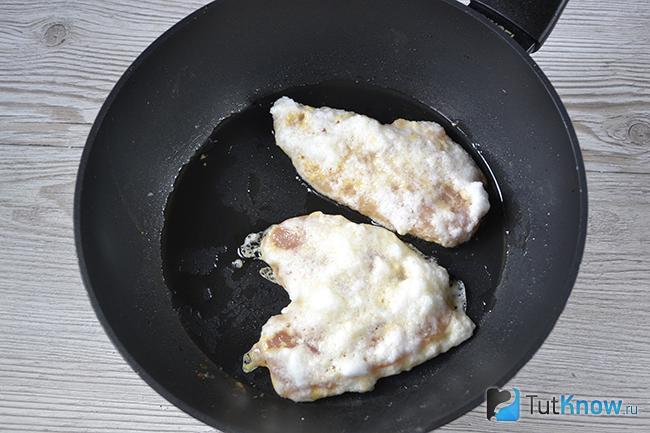 Куриные отбивные жарятся на сковороде