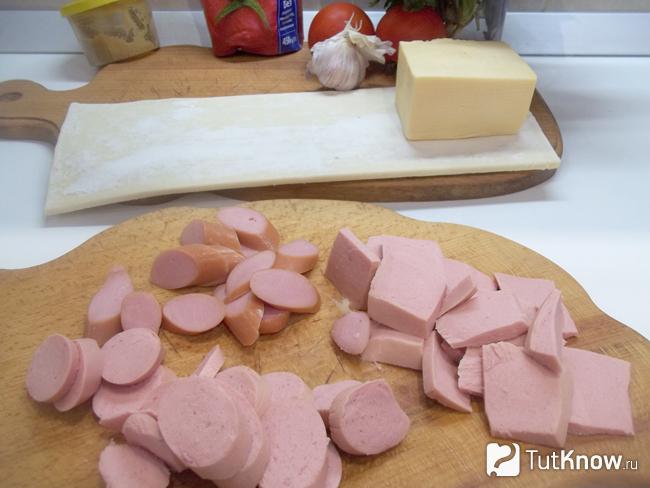 Колбаса и сосиски нарезаны кусочками