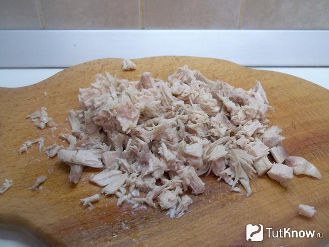 Отваренное куриное мясо нарезано кусочками