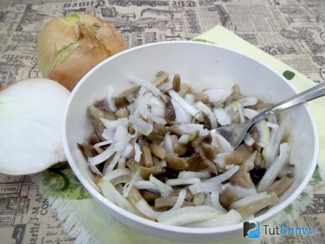 Готовый салат с маринованными грибами, луком и маслом