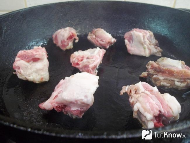 Мясо нарезано на кусочки и жарится в сковороде